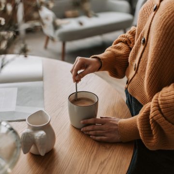 Girl in yellow stirring a cup of tea